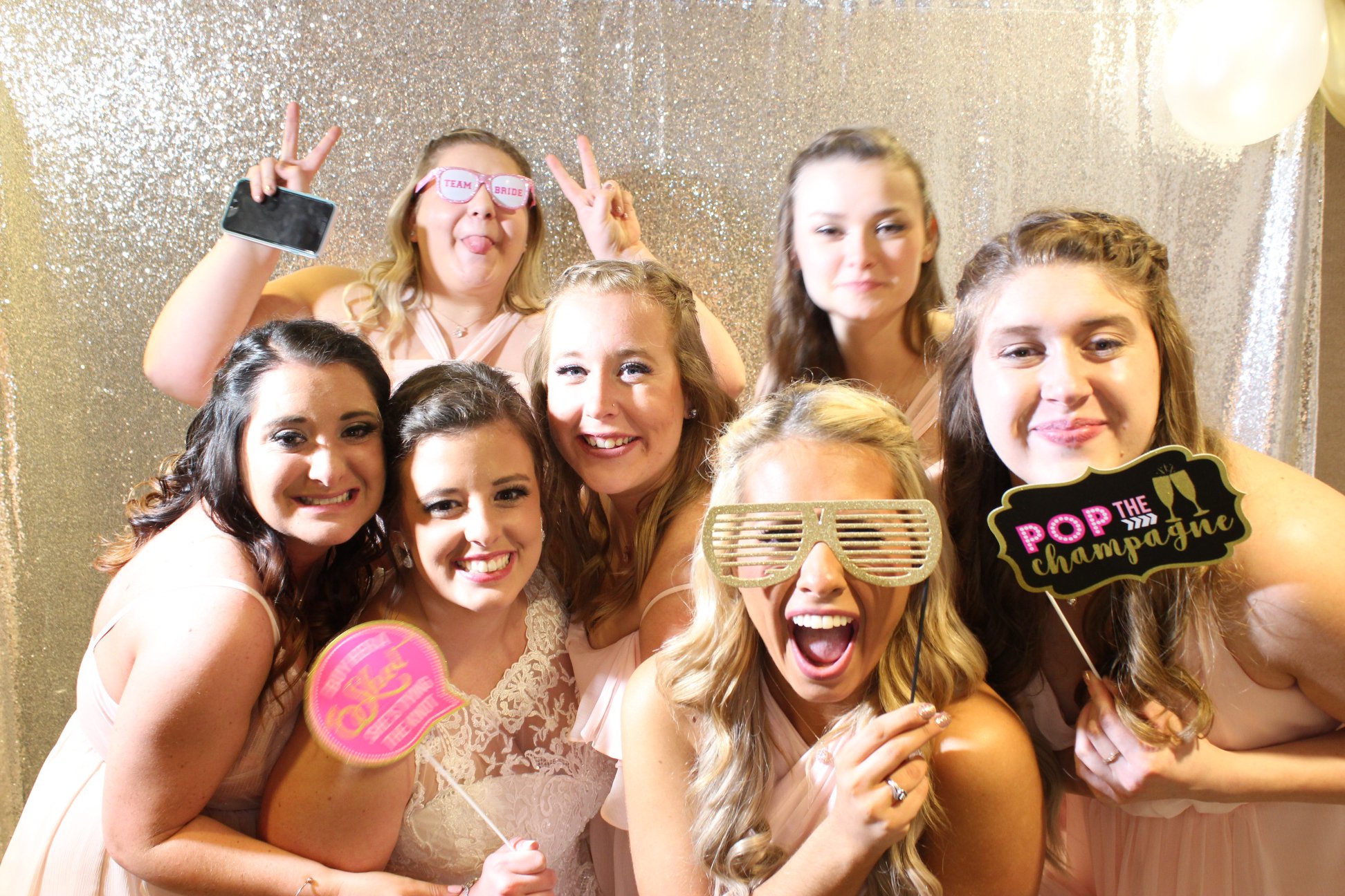 An image of bridesmaids posing for a photobooth picture.